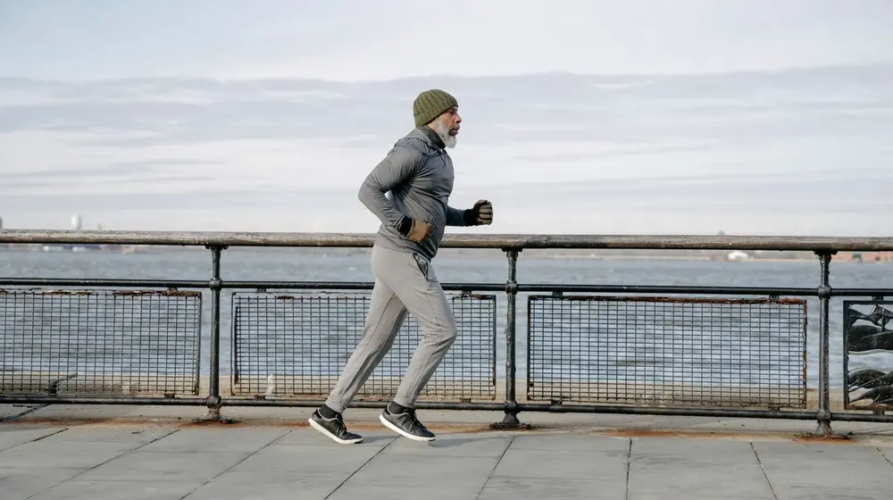 Active mature man over 40 running outdoors to rebuild energy, drive and stamina